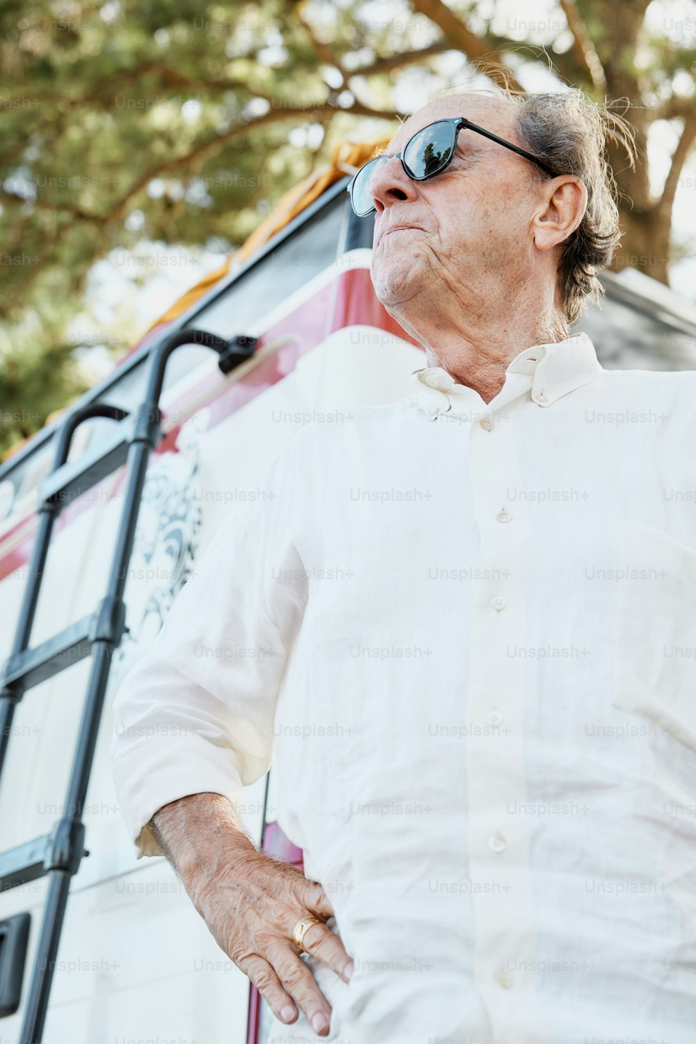 um homem usando óculos escuros em pé ao lado de um caminhão