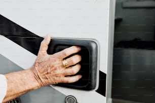 a man's hand is pressing a button on a bus