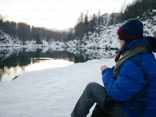 Eine Frau in blauer Jacke sitzt im Schnee