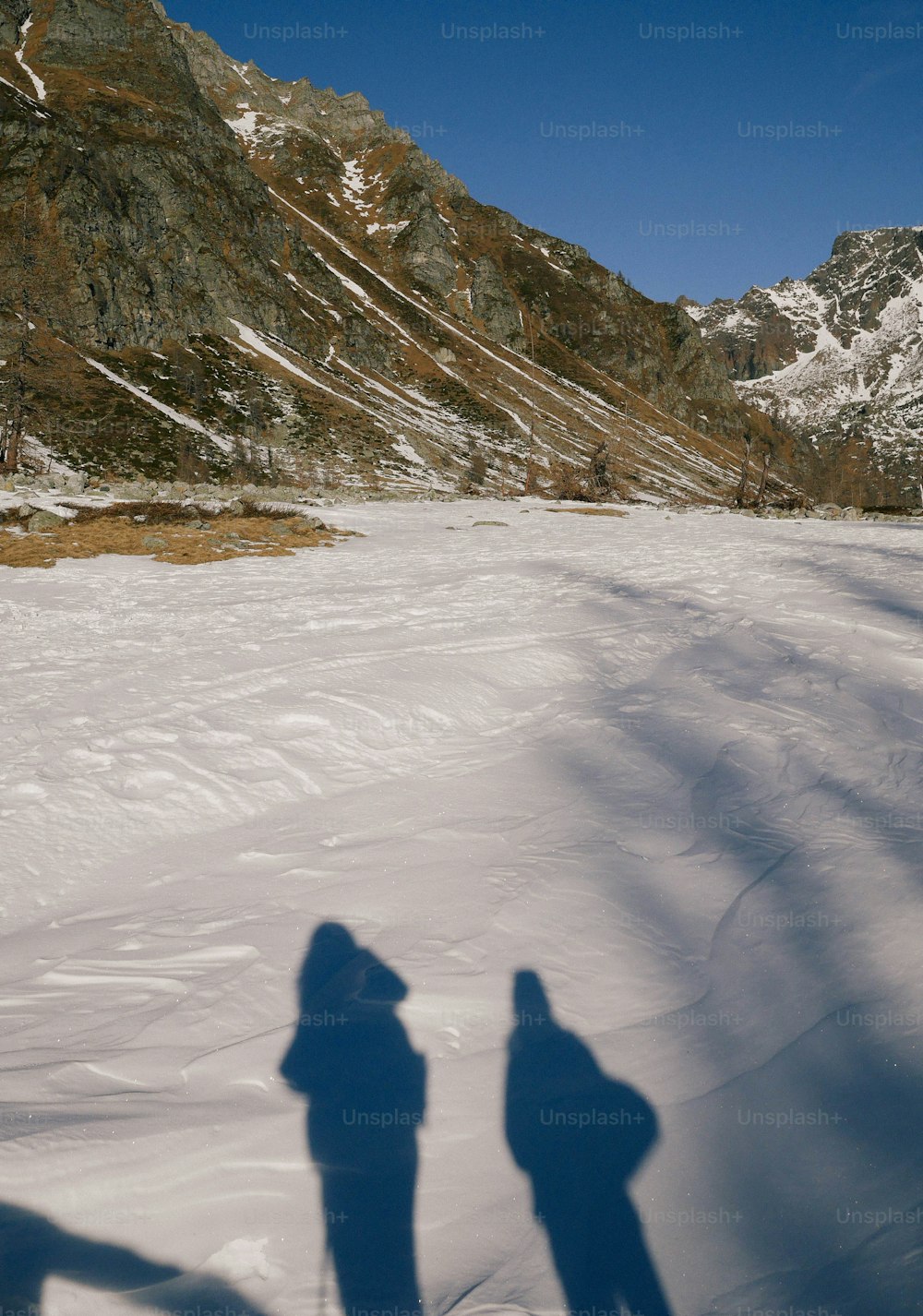 a couple of people standing on top of a snow covered slope