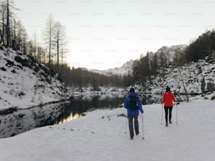 雪に覆われた野原を横切って歩くカップルの人々