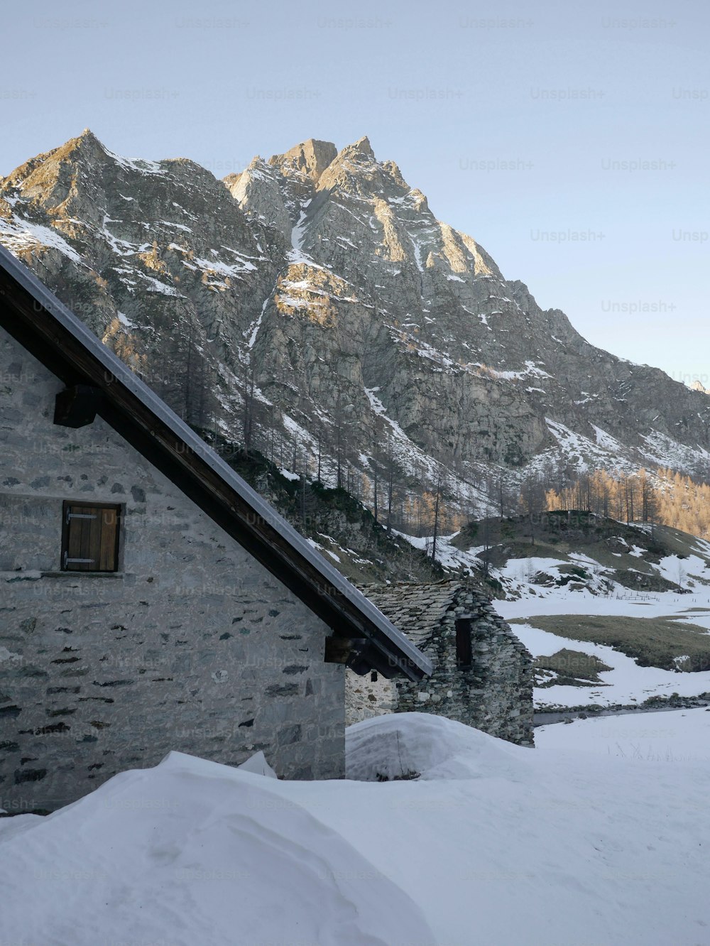uma casa na neve com uma montanha ao fundo