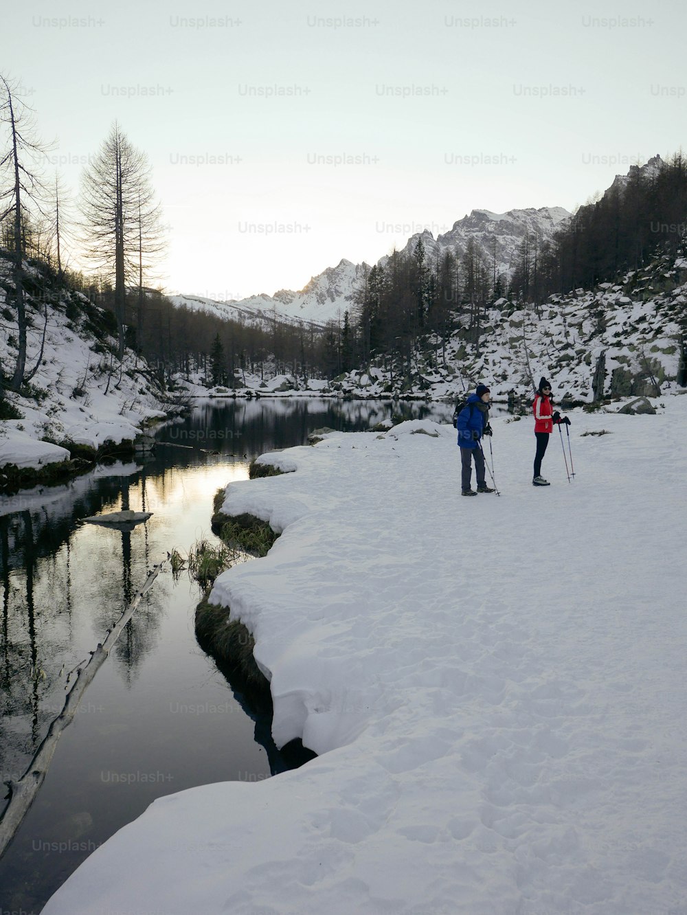 a couple of people on skis standing in the snow