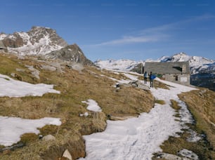 a couple of people walking up a snow covered hill