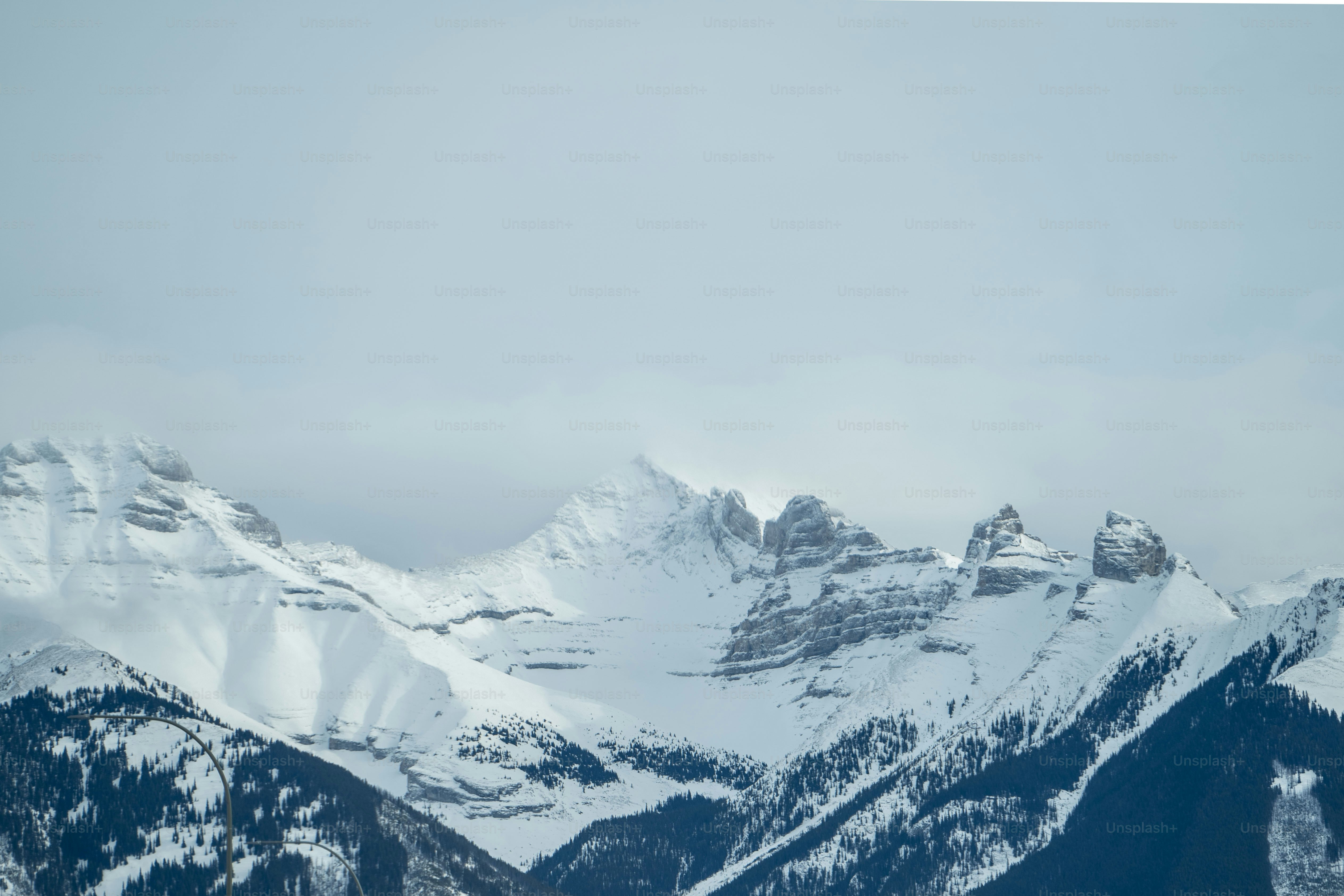 Eine Gruppe schneebedeckter Berge unter einem bewölkten Himmel