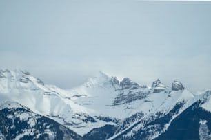 a group of mountains covered in snow under a cloudy sky