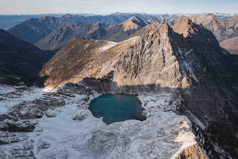 eine schneebedeckte Bergkette mit einem See in der Mitte