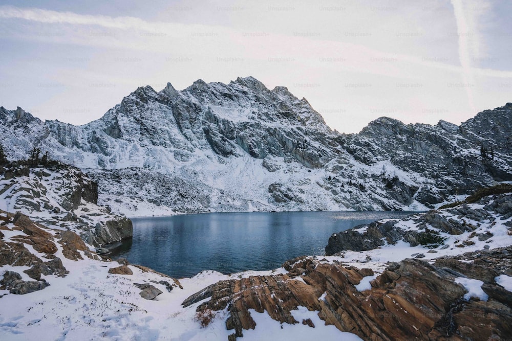 uma montanha com um lago cercado por neve