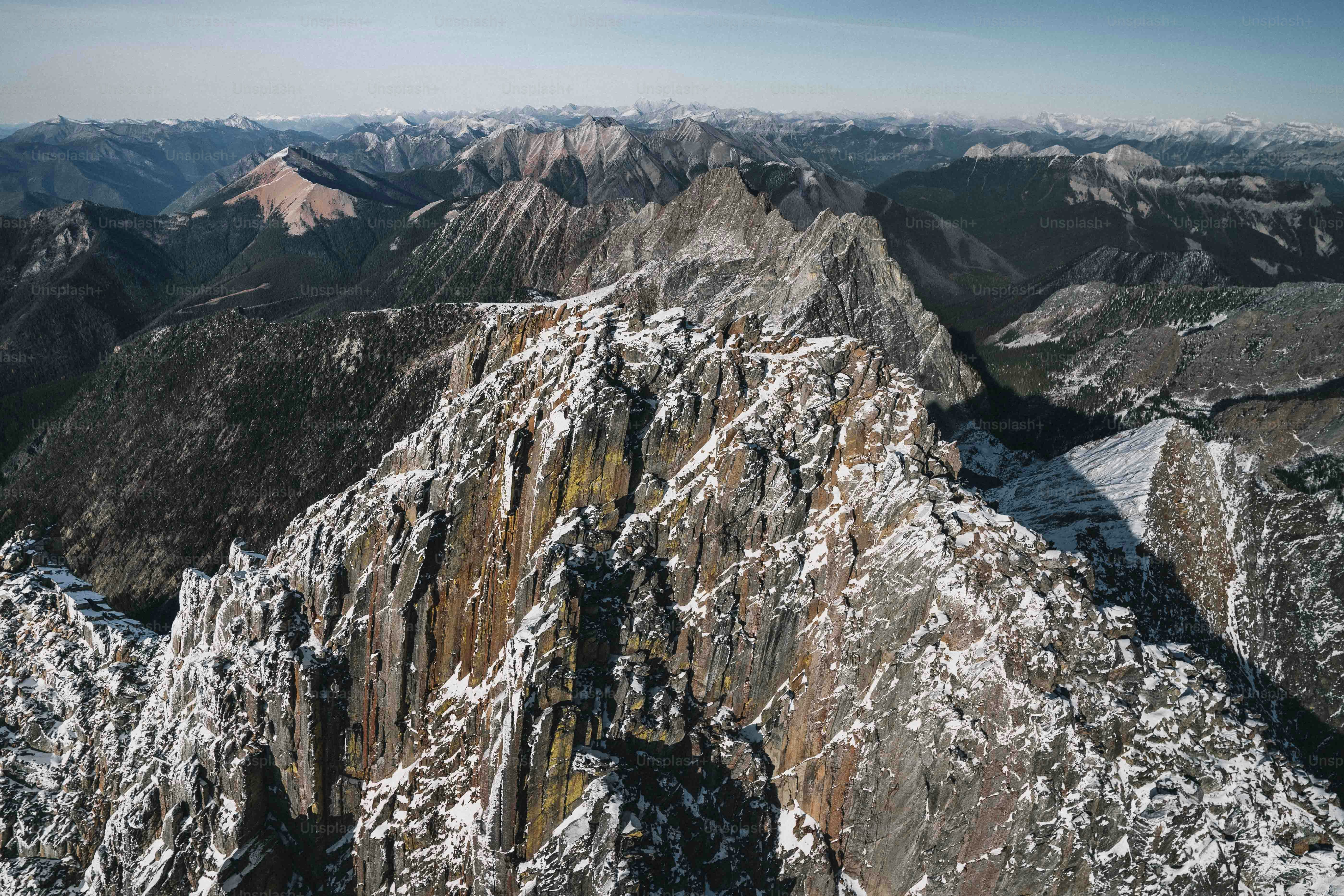 eine schneebedeckte Bergkette mit Bergen im Hintergrund