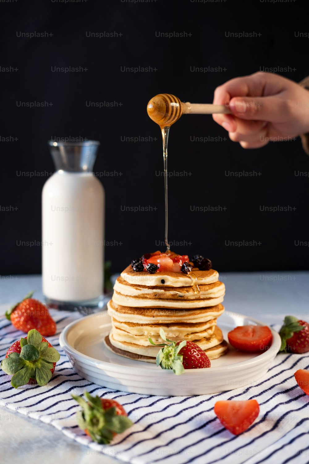 a stack of pancakes with syrup being drizzled on top
