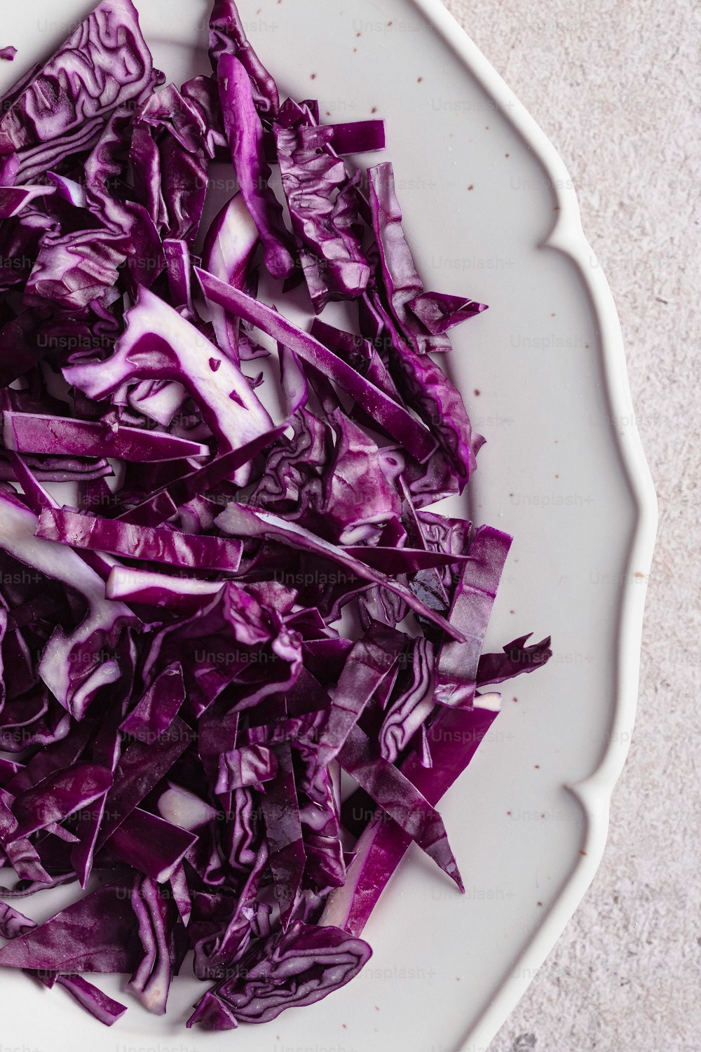 a white plate topped with sliced red cabbage