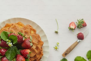 a white plate topped with waffles covered in strawberries