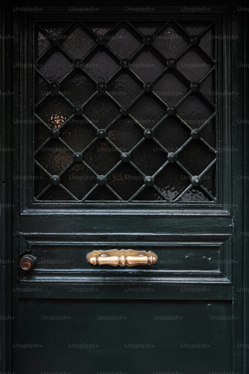 a close up of a black door with a wooden handle