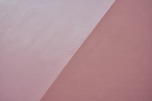 a person riding a skateboard on top of a pink wall