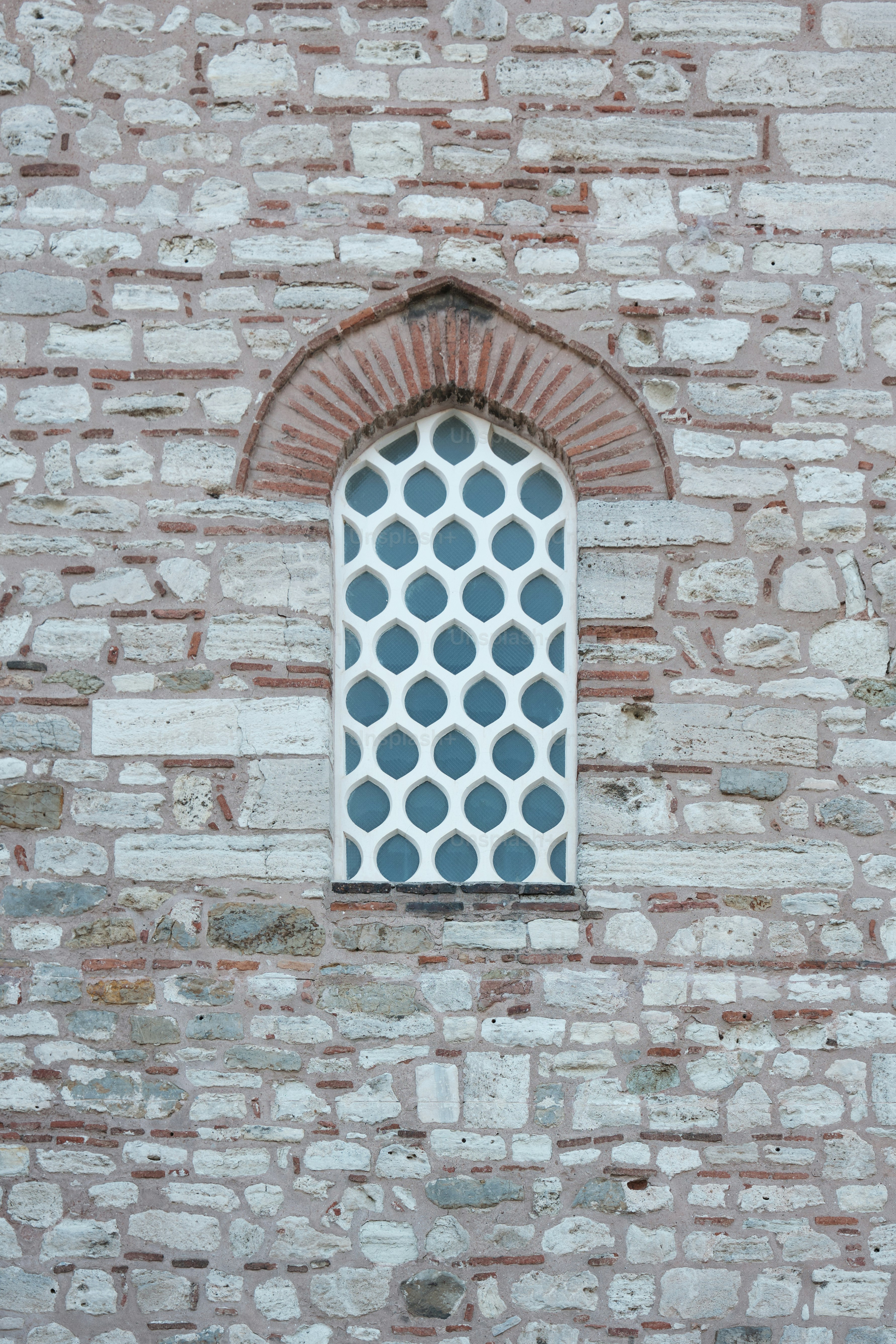 a brick wall with a window and a brick arch