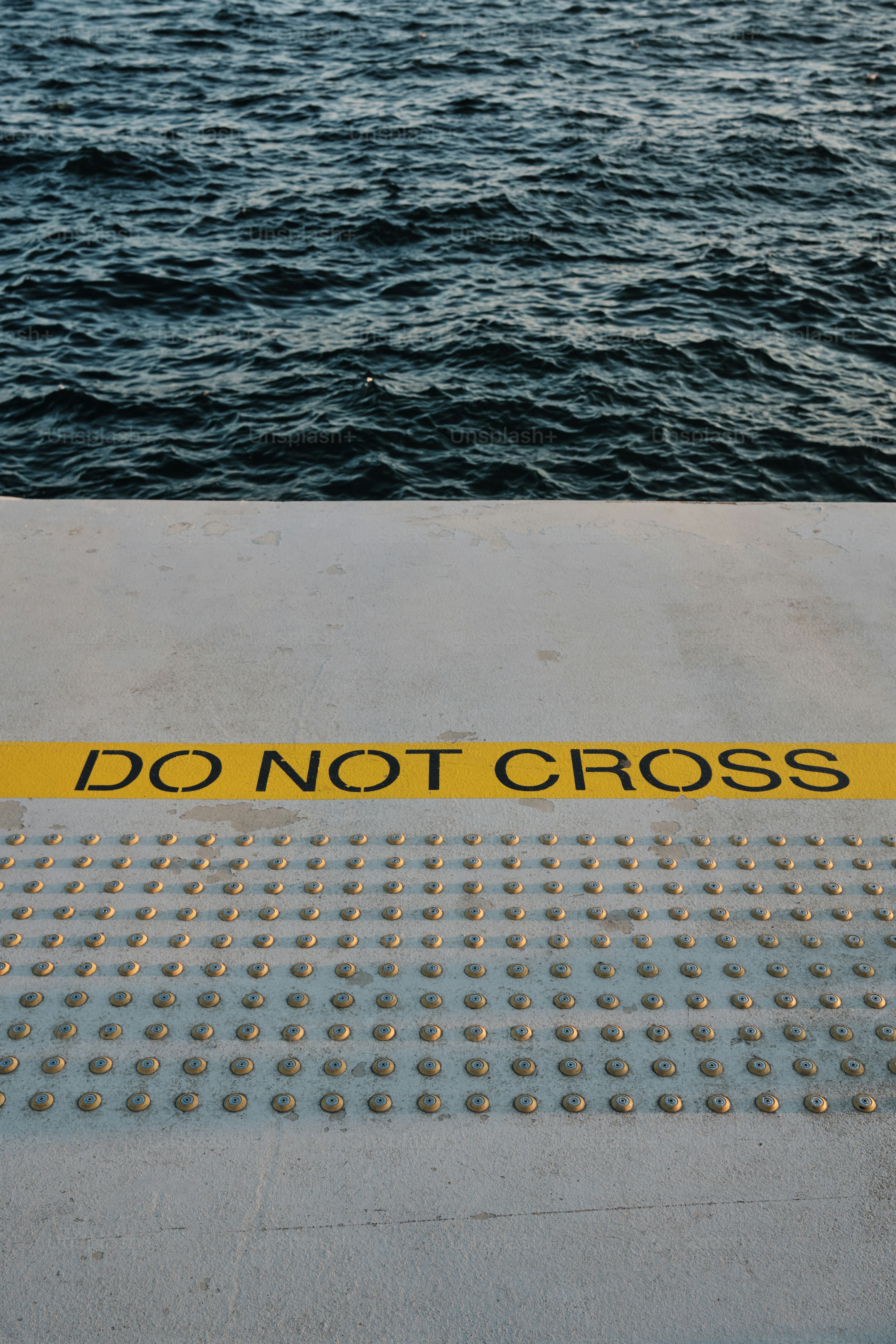 Ein gelbes "Do Not Cross"-Schild, das an der Seite eines Bootes sitzt