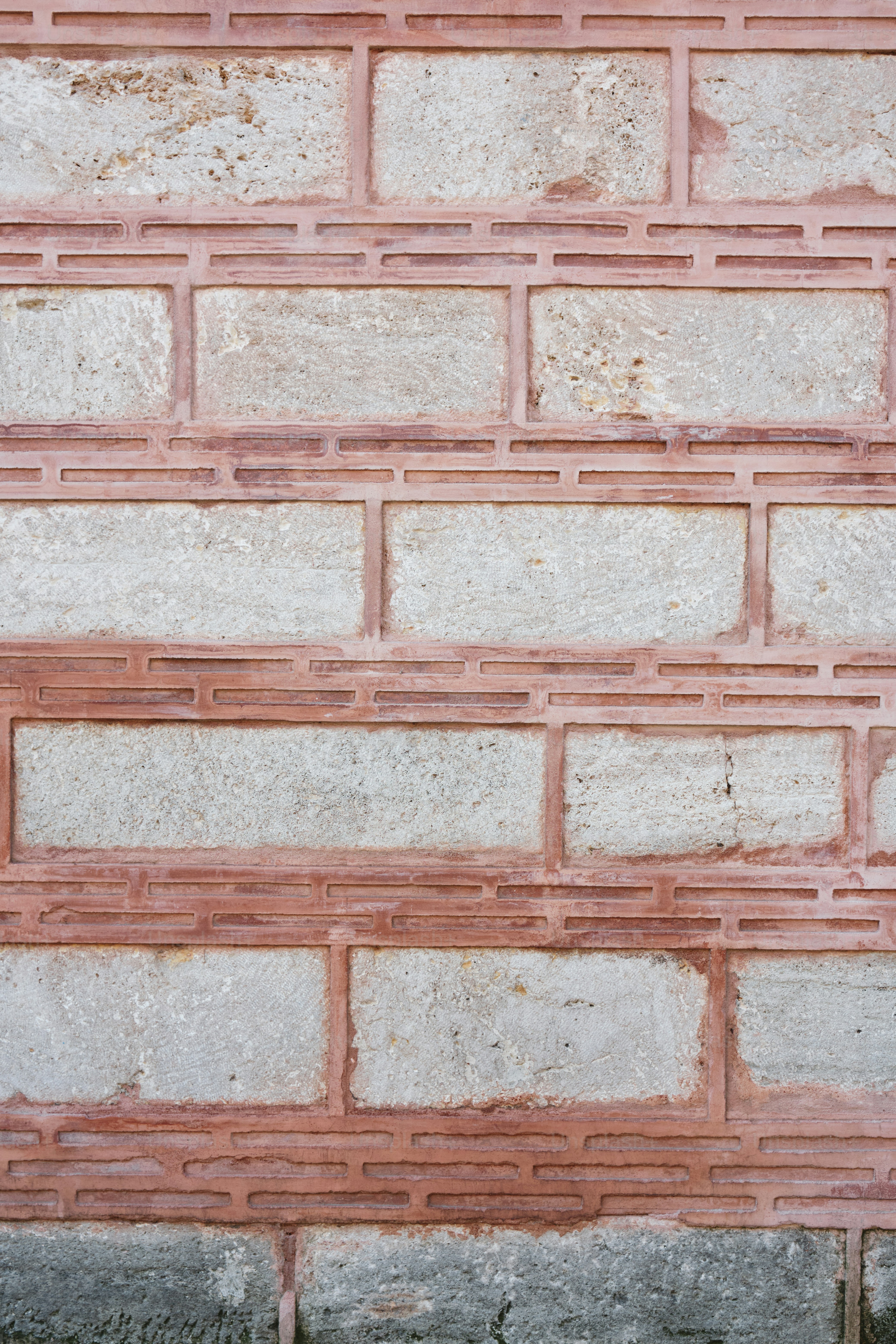 a red fire hydrant in front of a brick wall