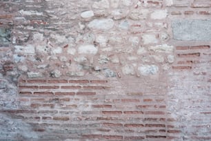 Un idrante rosso seduto sul lato di un muro di mattoni
