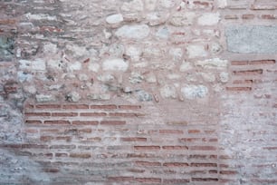 a red fire hydrant sitting on the side of a brick wall