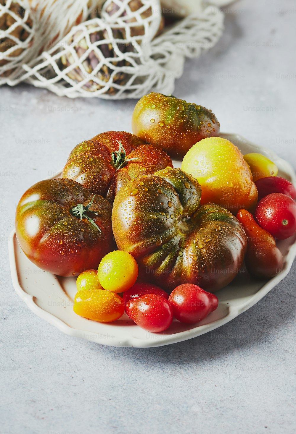 a white plate topped with lots of different types of tomatoes