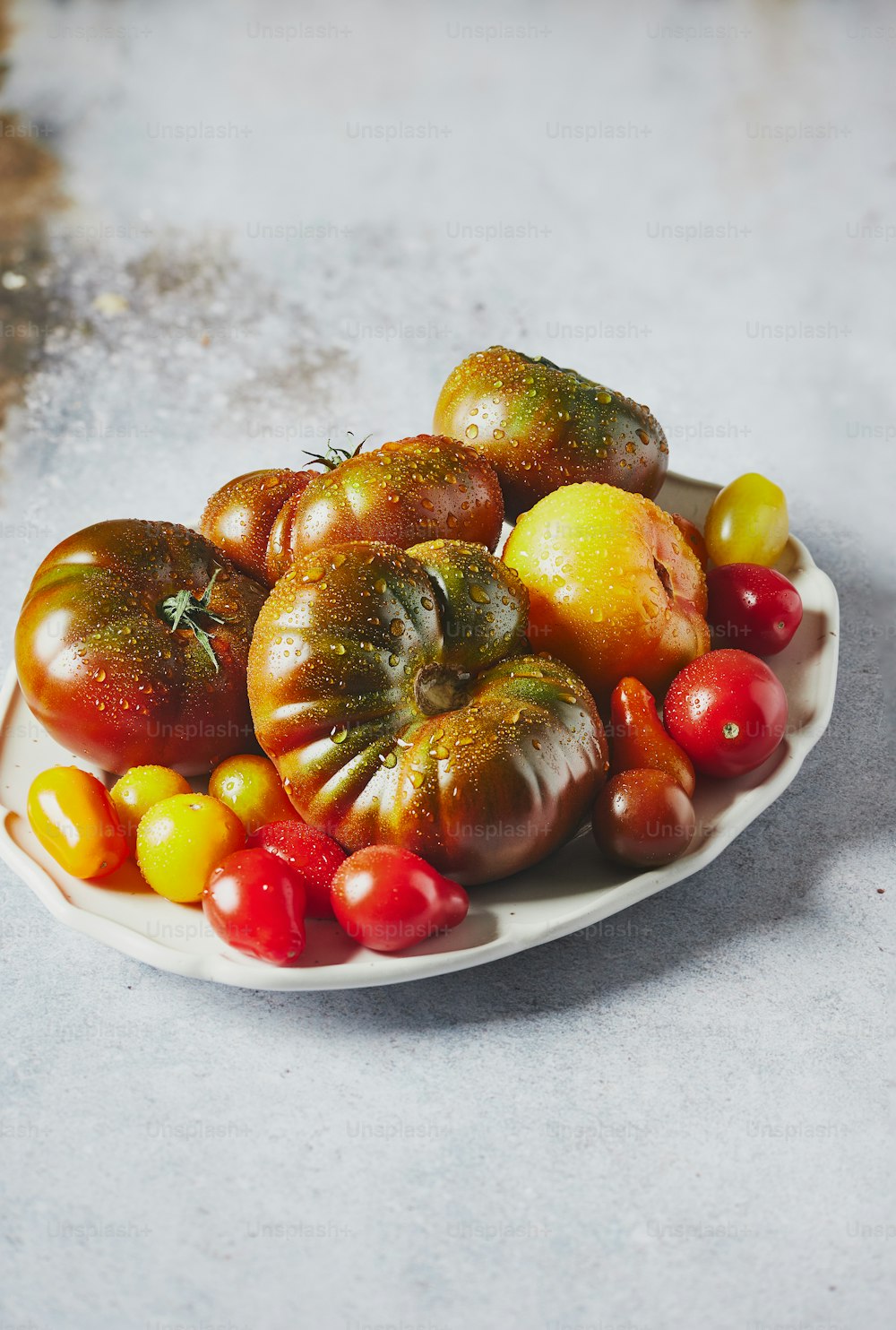a white plate filled with lots of different types of tomatoes