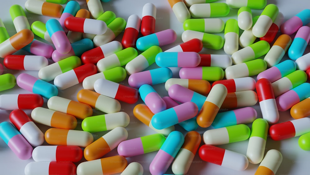 Una pila de píldoras multicolores sobre una superficie blanca