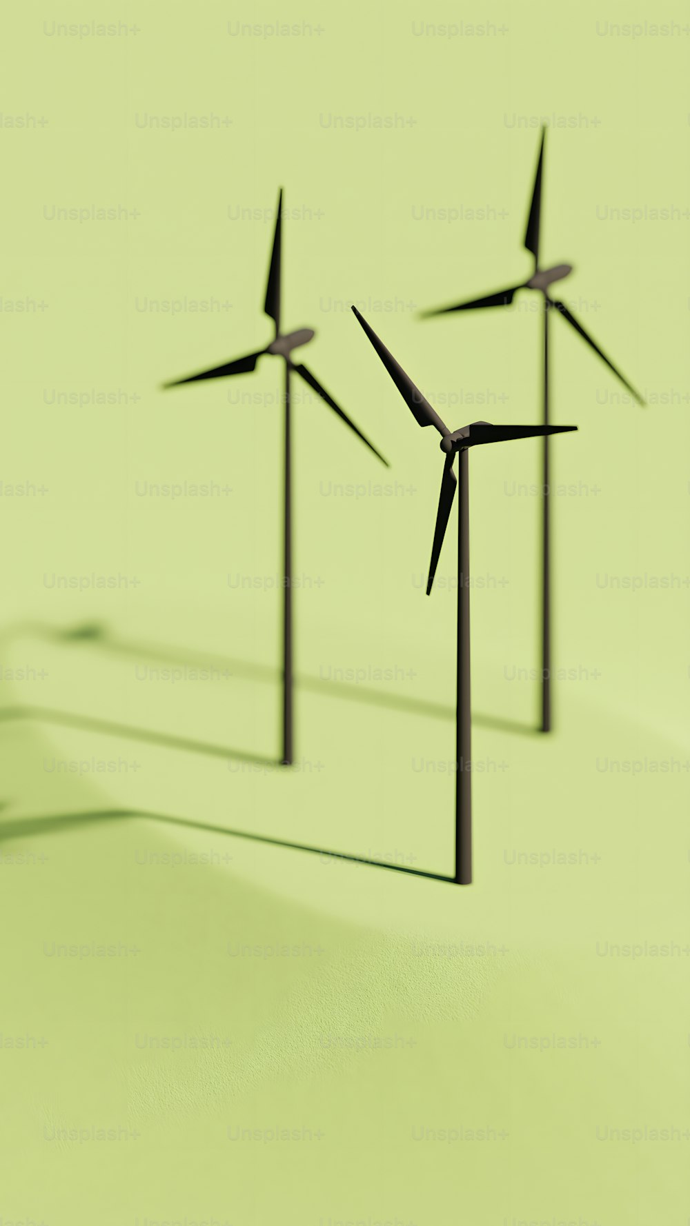 a group of three wind turbines on a green surface