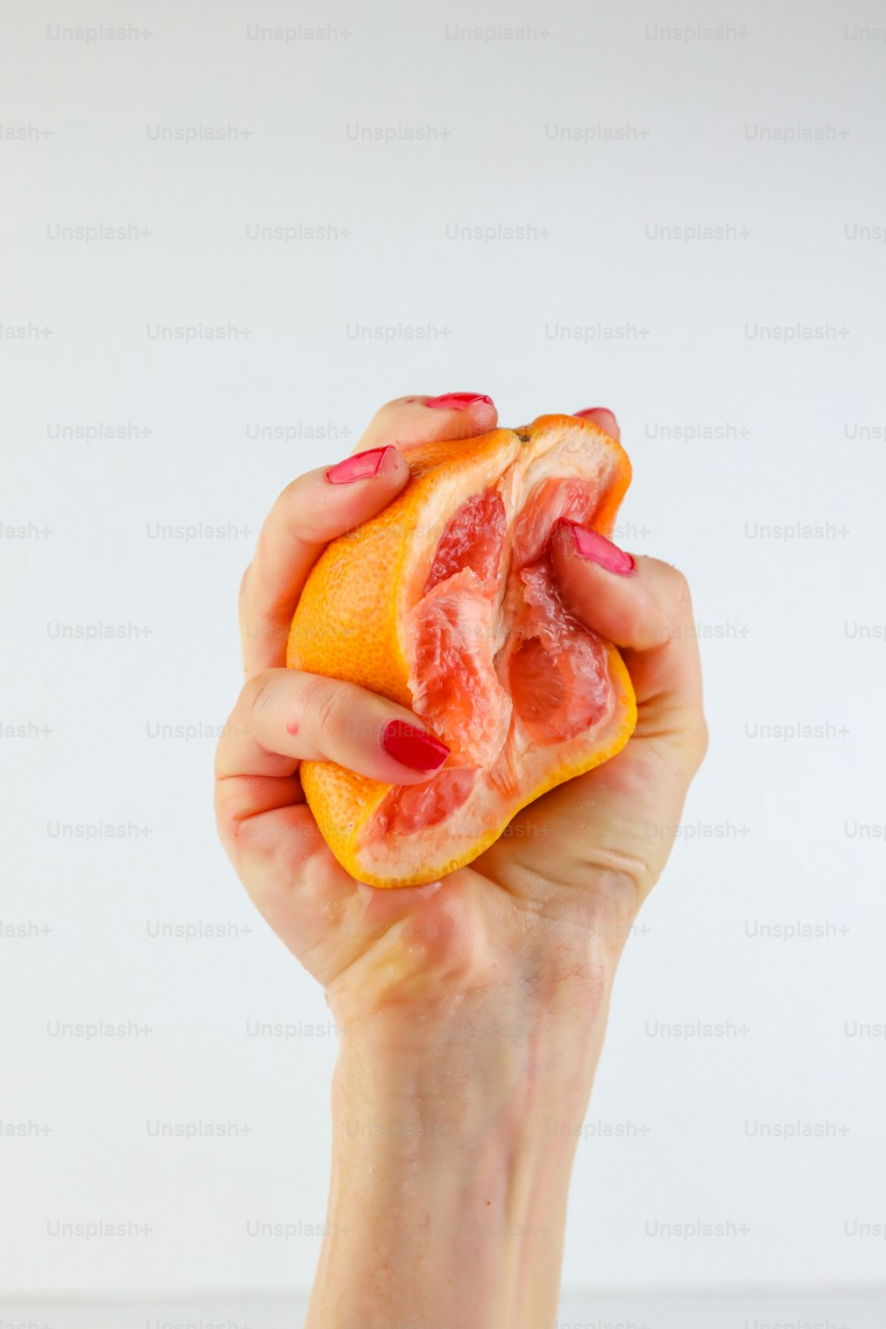 a person holding a grapefruit in their hand