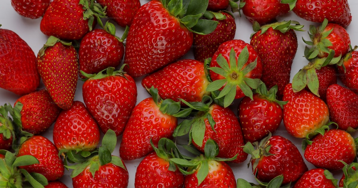 A large group of strawberries on a white surface photo – Red fruit ...