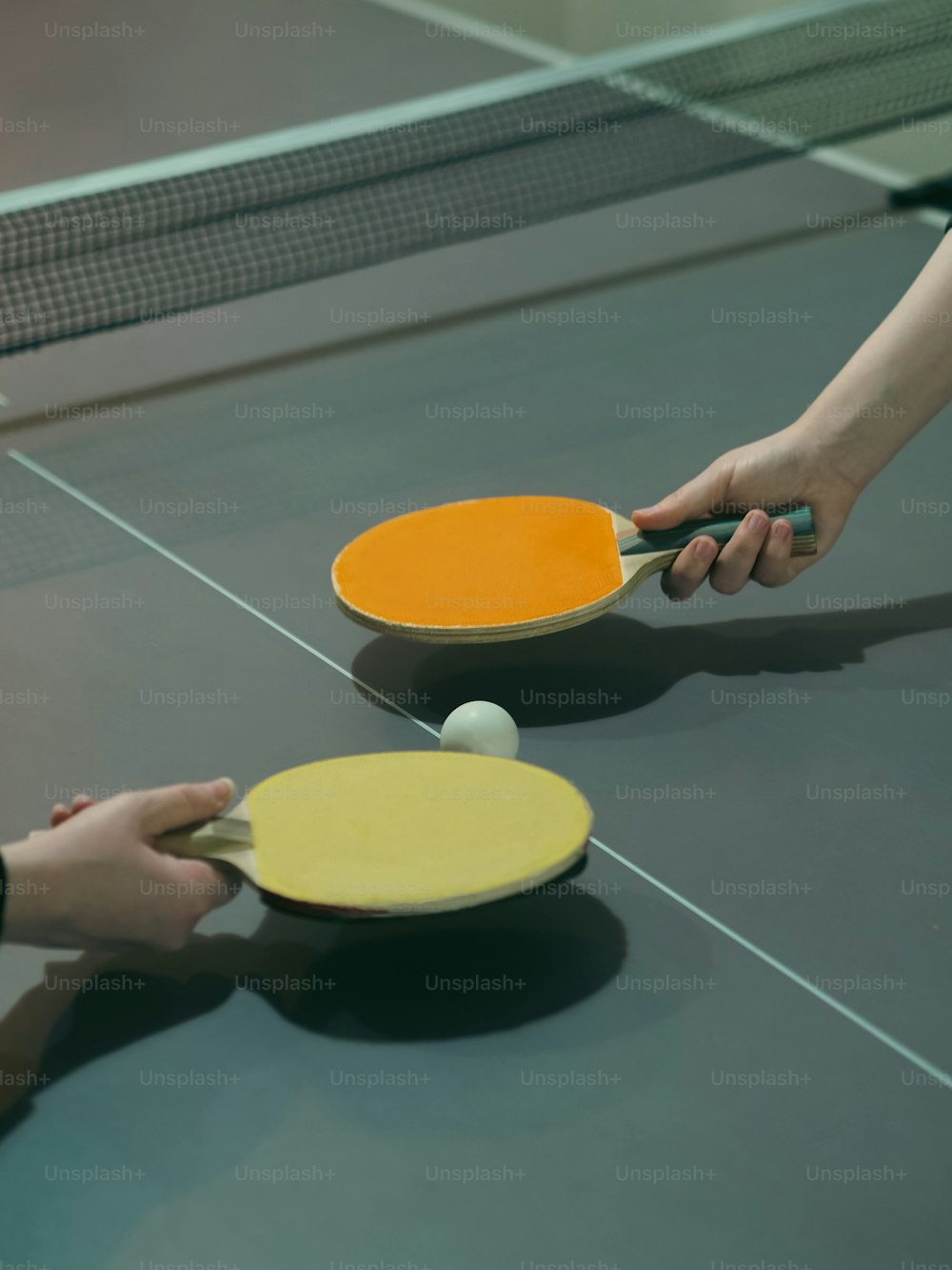 Due persone stanno giocando a ping pong su un tavolo da ping pong