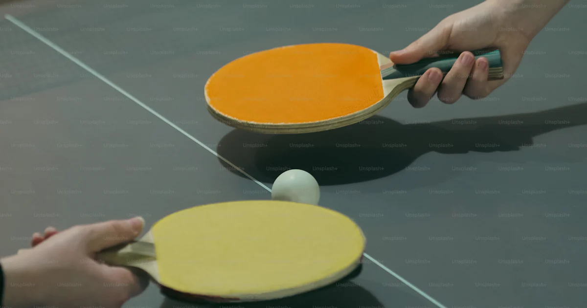 Two people are playing ping pong on a ping pong table photo – Exercise ...