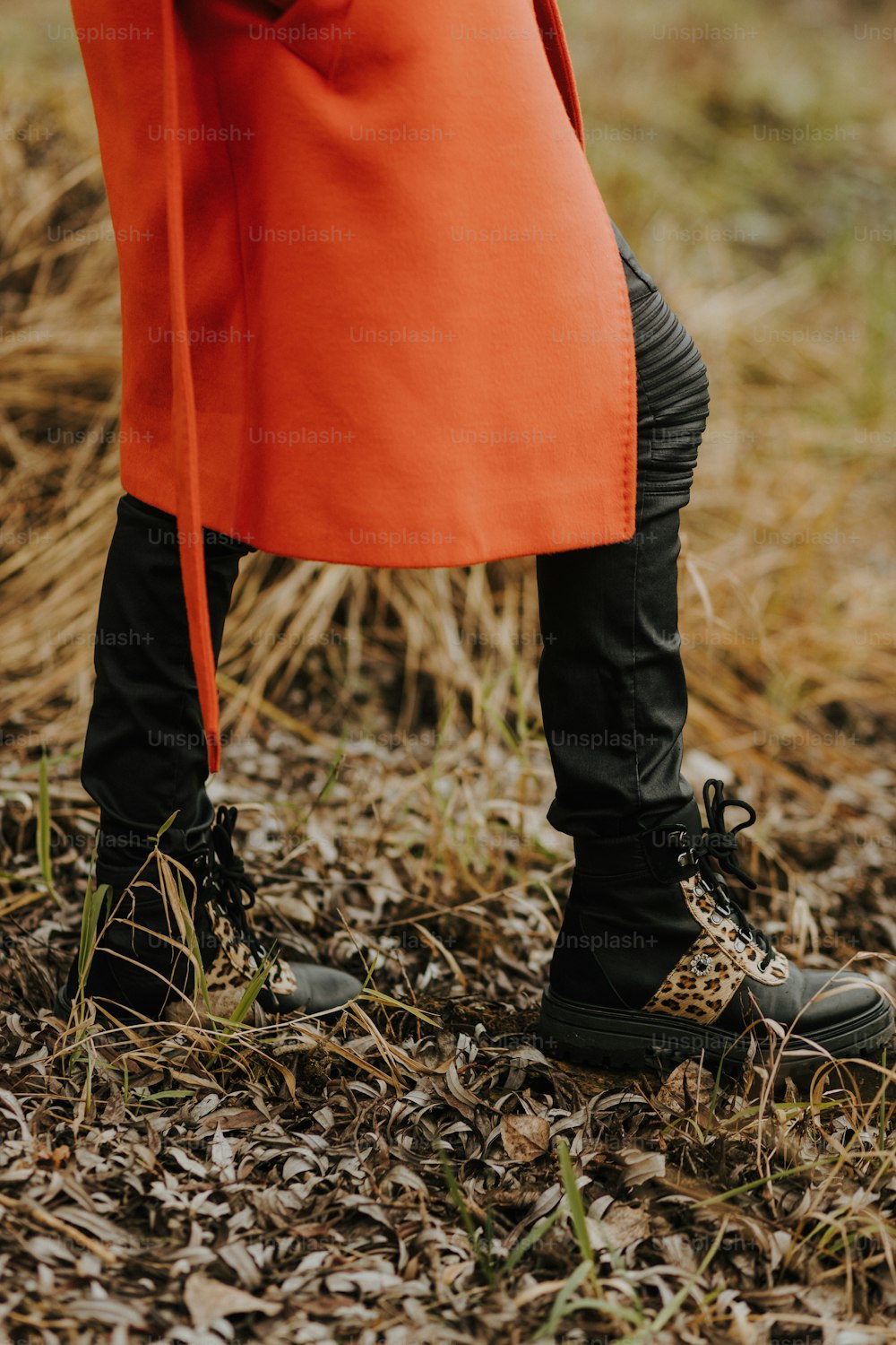 a person in an orange coat and black boots