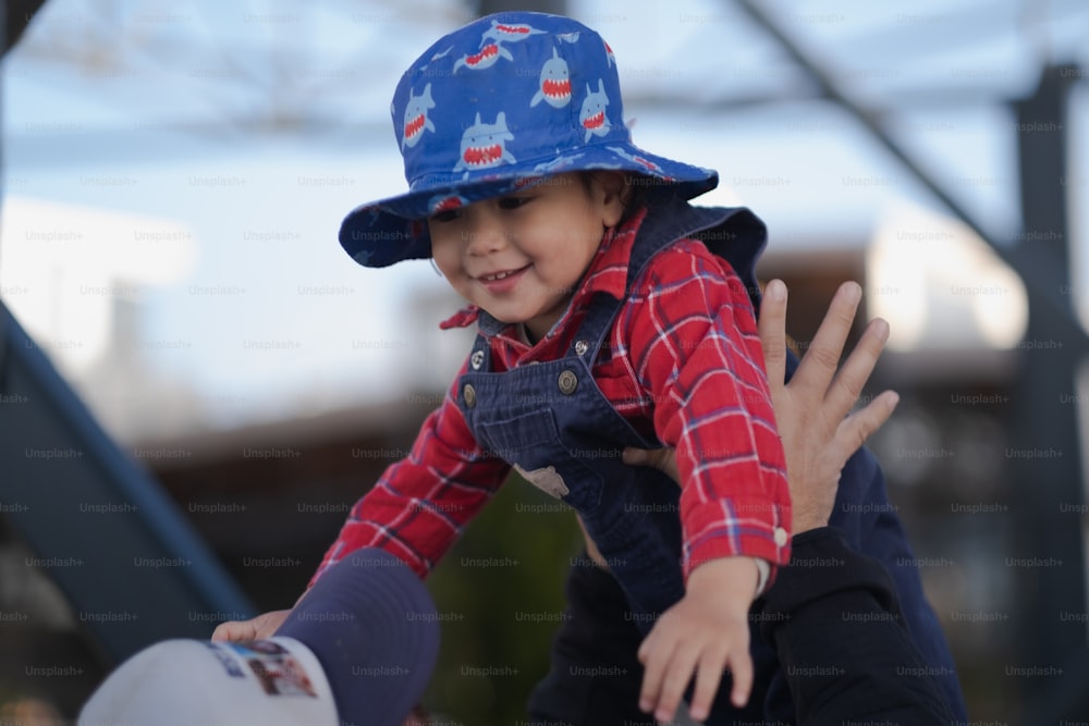 um menino vestindo um chapéu azul segurando um frisbee branco