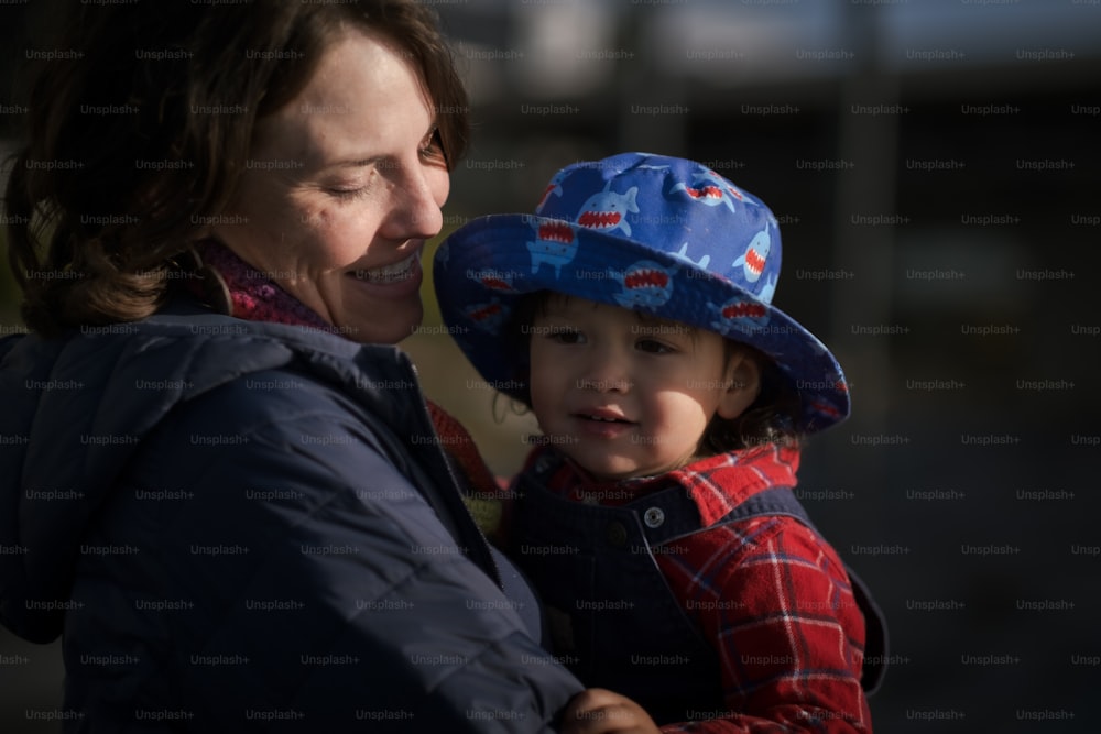 Una mujer sosteniendo a un niño con un sombrero azul