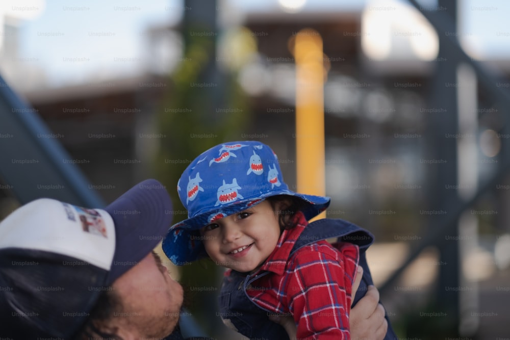 Un hombre sosteniendo a un niño pequeño con un sombrero
