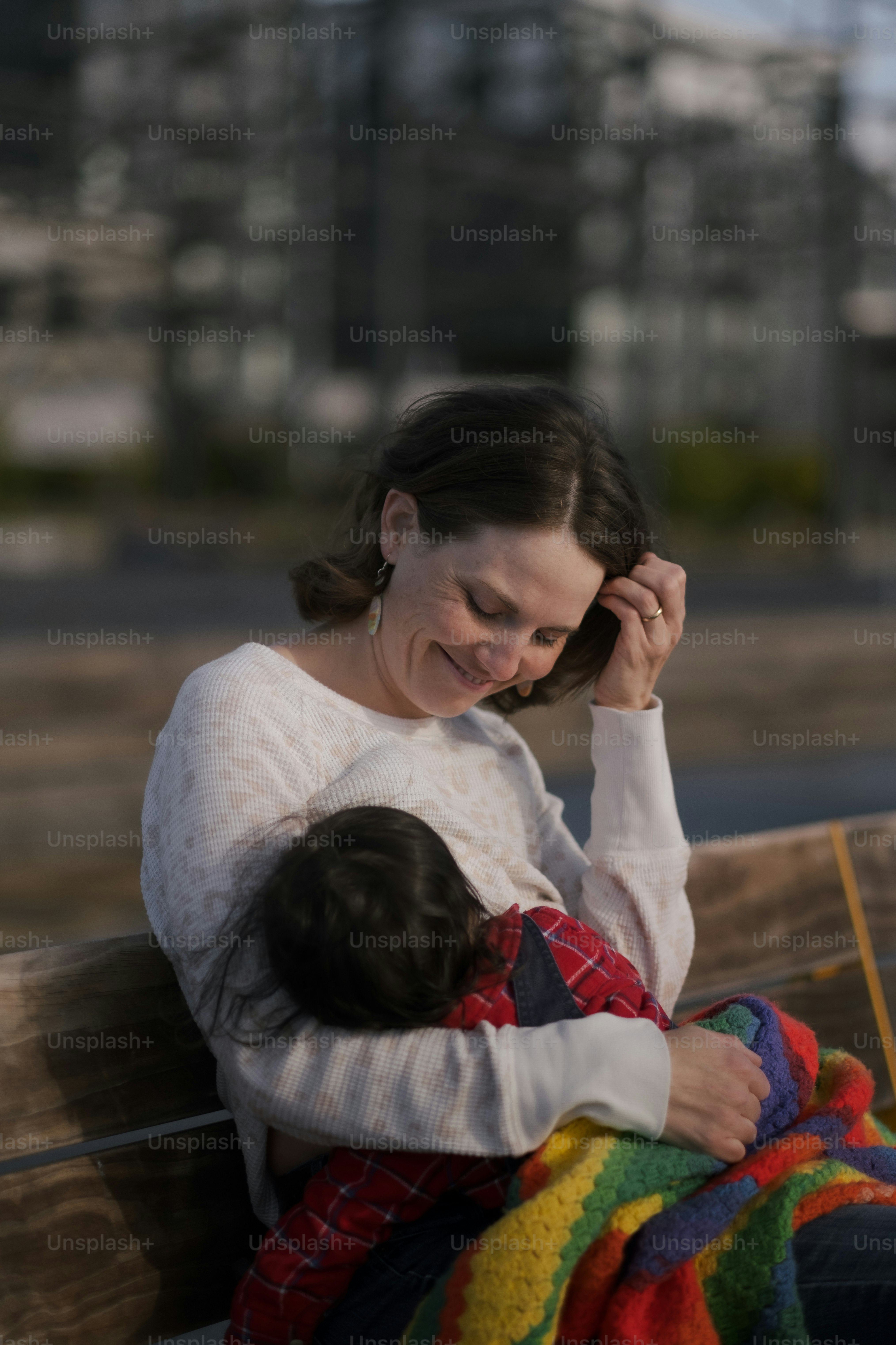 a woman sitting on a bench holding a baby
