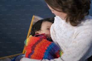 Una mujer sosteniendo a un niño envuelto en una manta