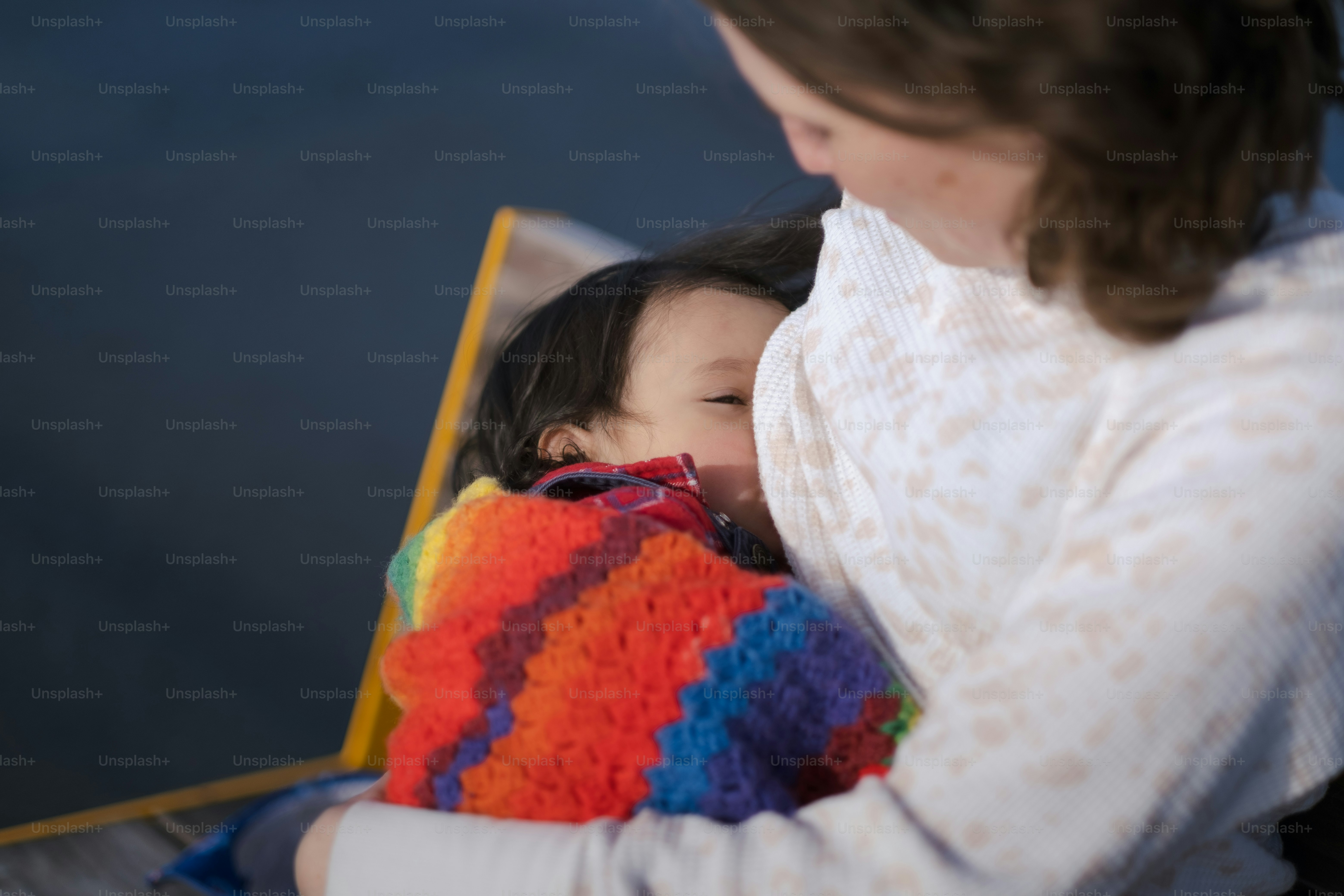 a woman holding a baby wrapped in a blanket