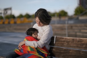 a woman holding a child wrapped in a blanket