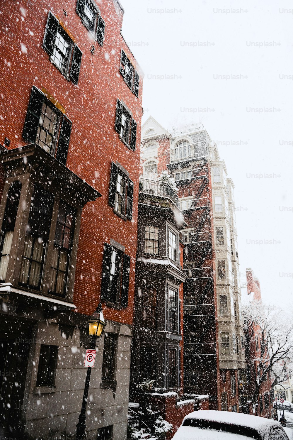 건물과 자동차가있는 도시에서 눈 오는 날