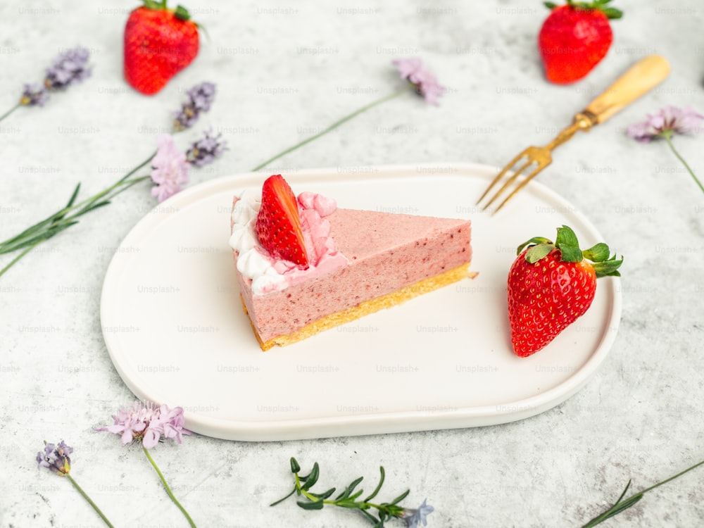 a slice of strawberry cheesecake on a plate with a fork