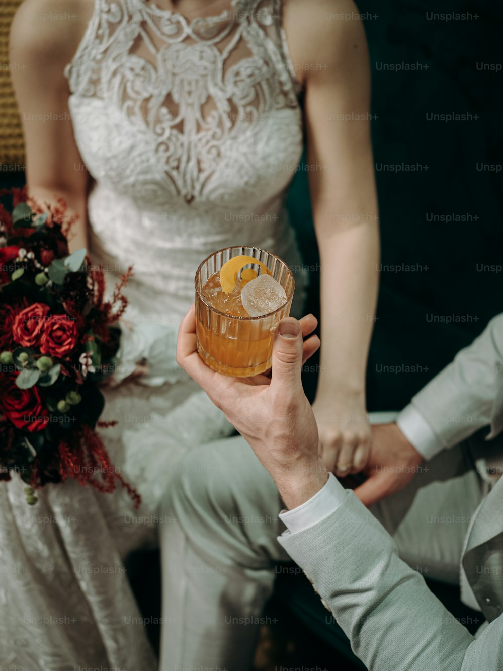 a bride and groom holding up a drink