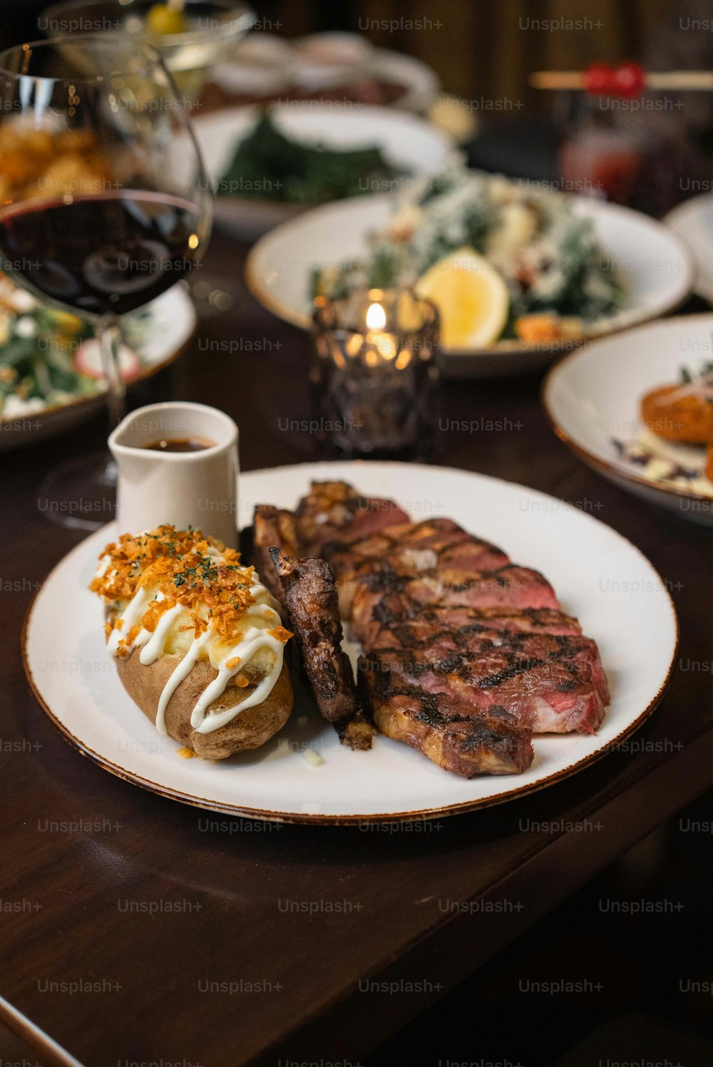 ein Teller mit Steak, Kartoffeln und Salat auf einem Tisch