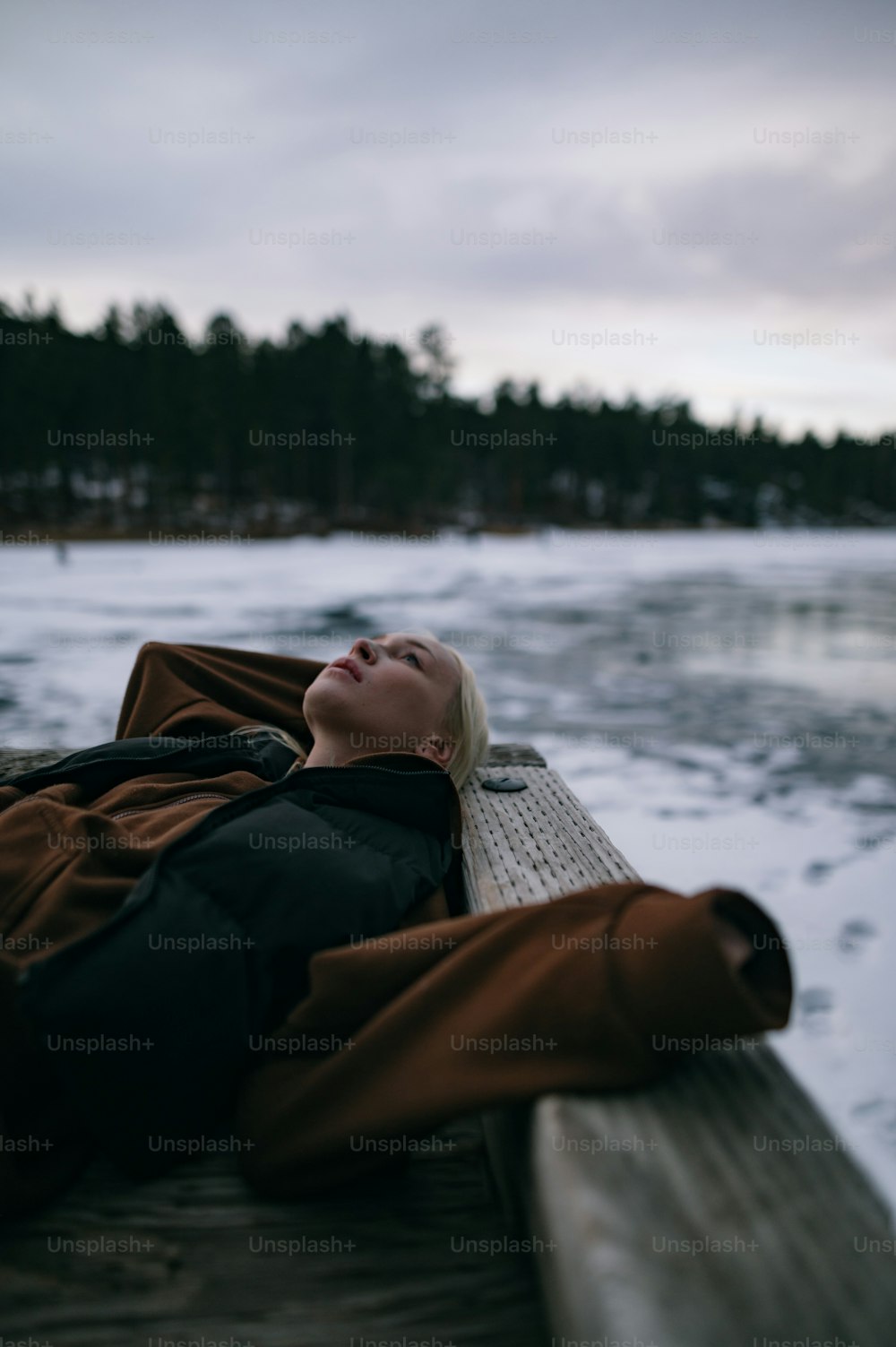 uma mulher deitada em uma doca na neve