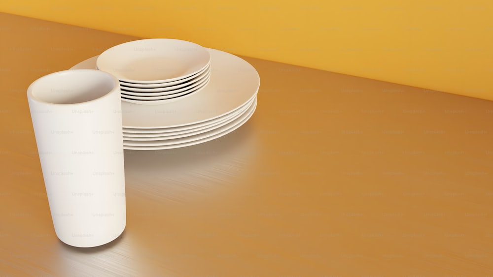 uma pilha de pratos brancos sentados em cima de uma mesa de madeira