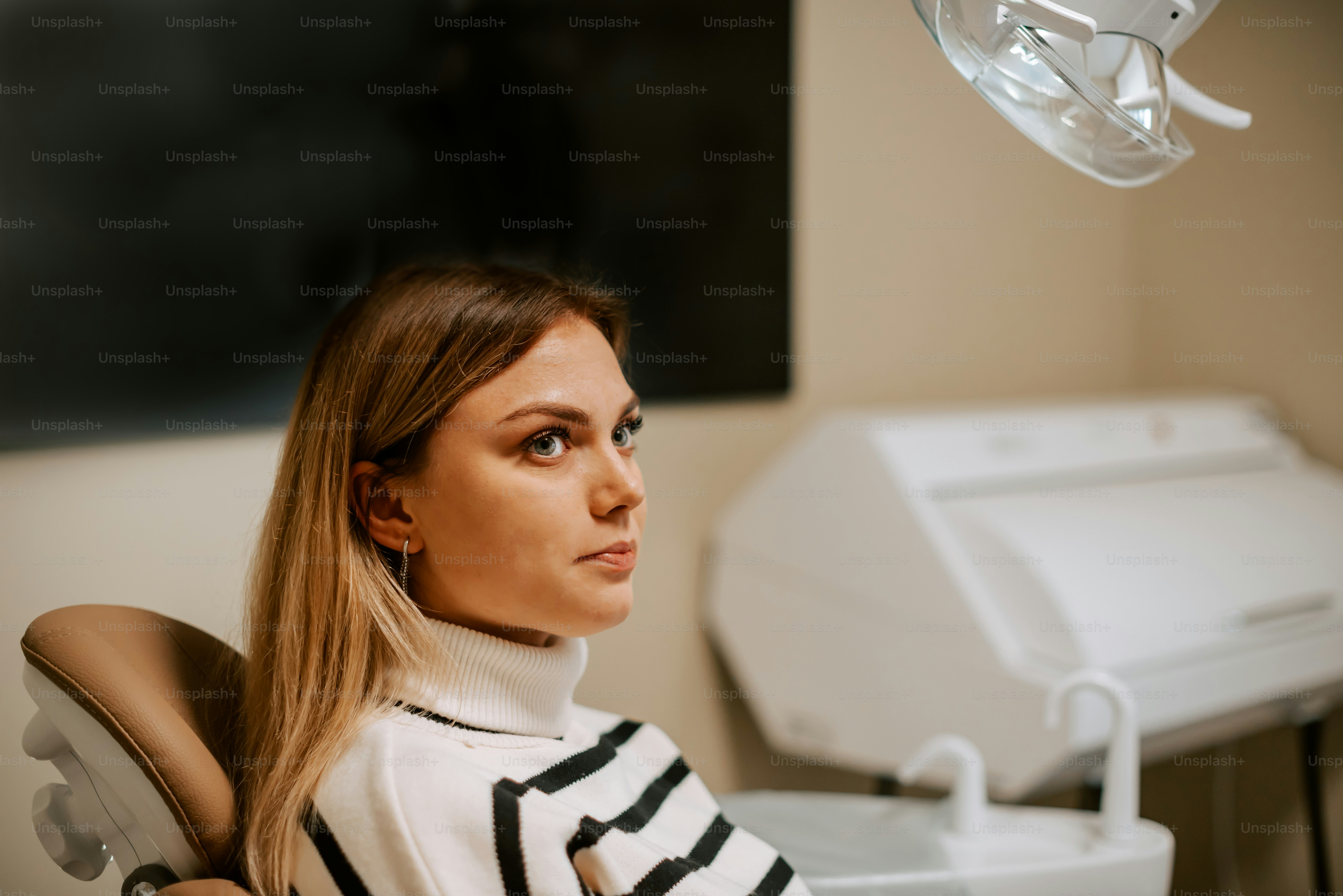 a woman sitting in a chair with a toothbrush in her mouth