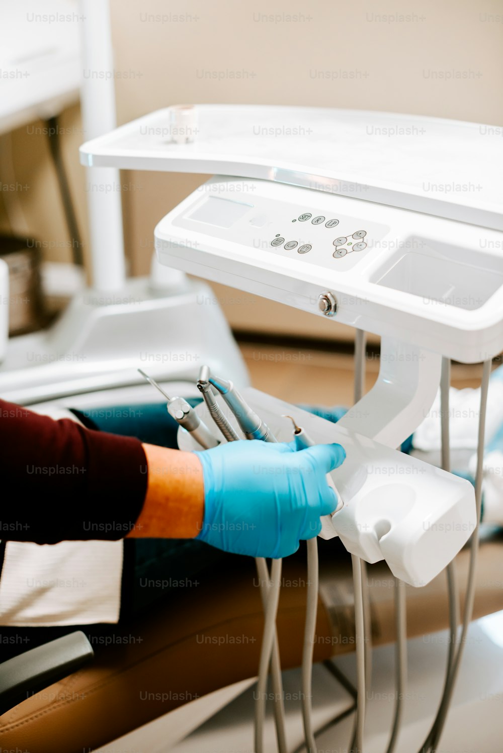 a person in a dentist chair with a pair of blue gloves