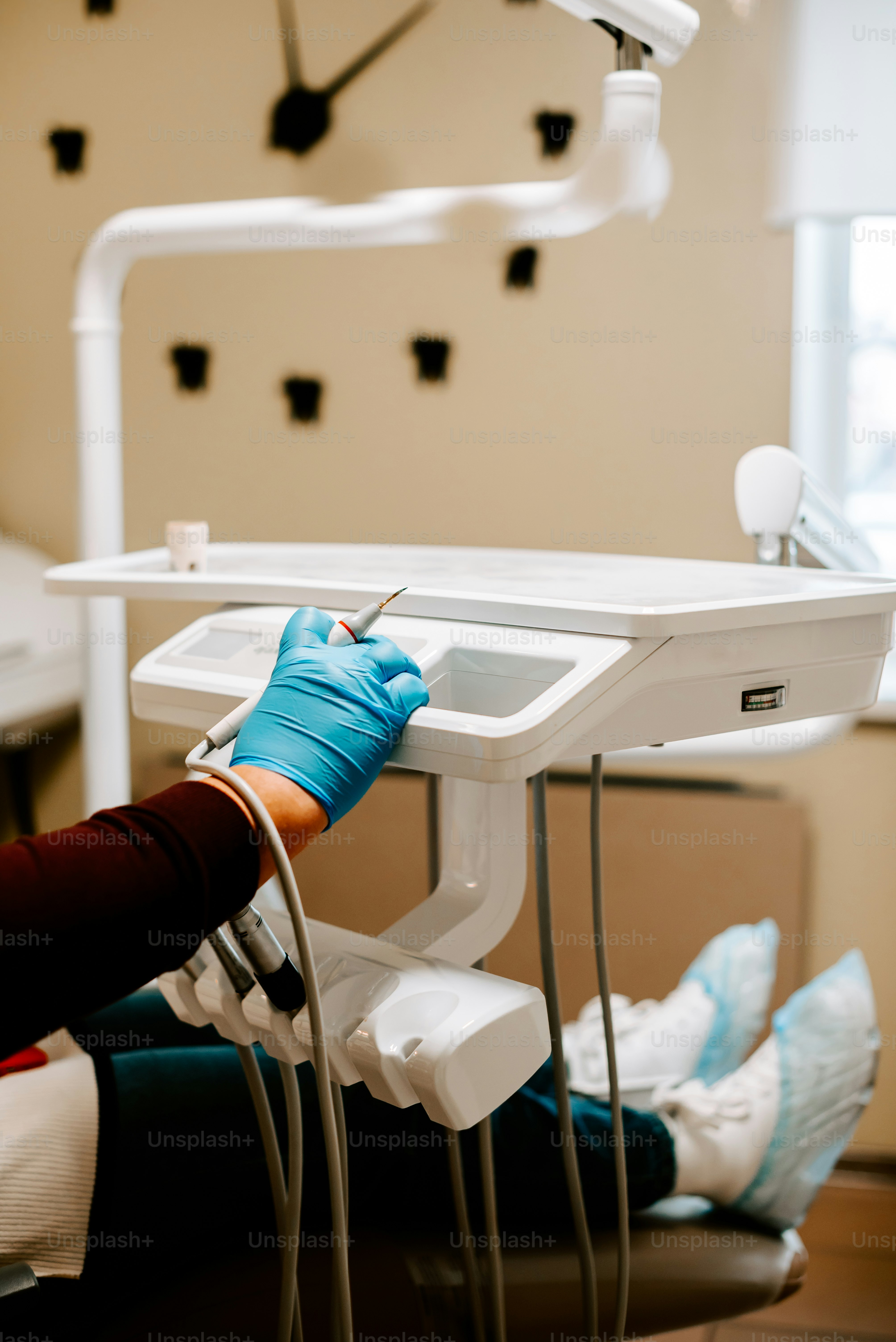 a person in blue gloves is sitting in a dentist chair