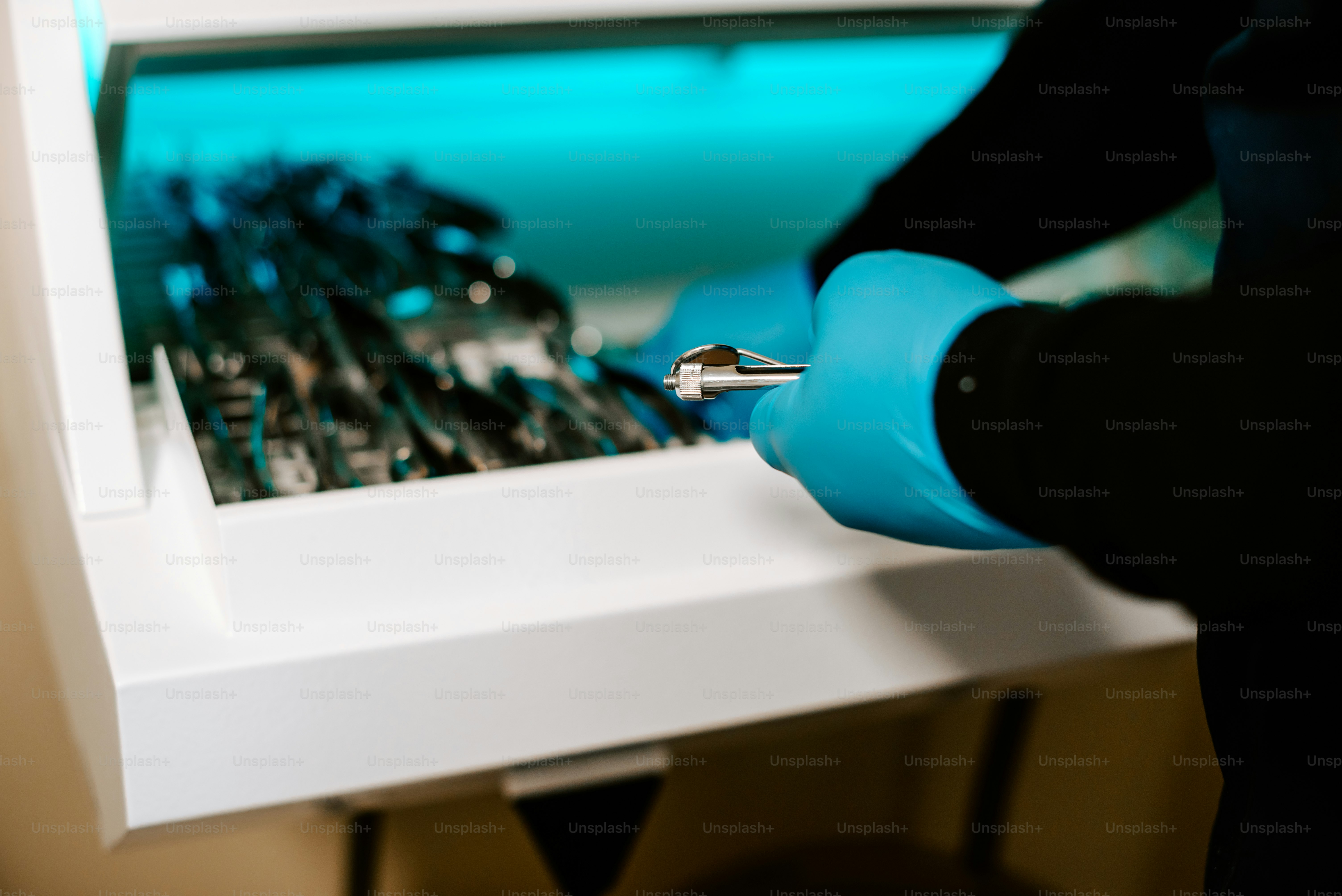 a person in blue gloves is holding a screwdriver