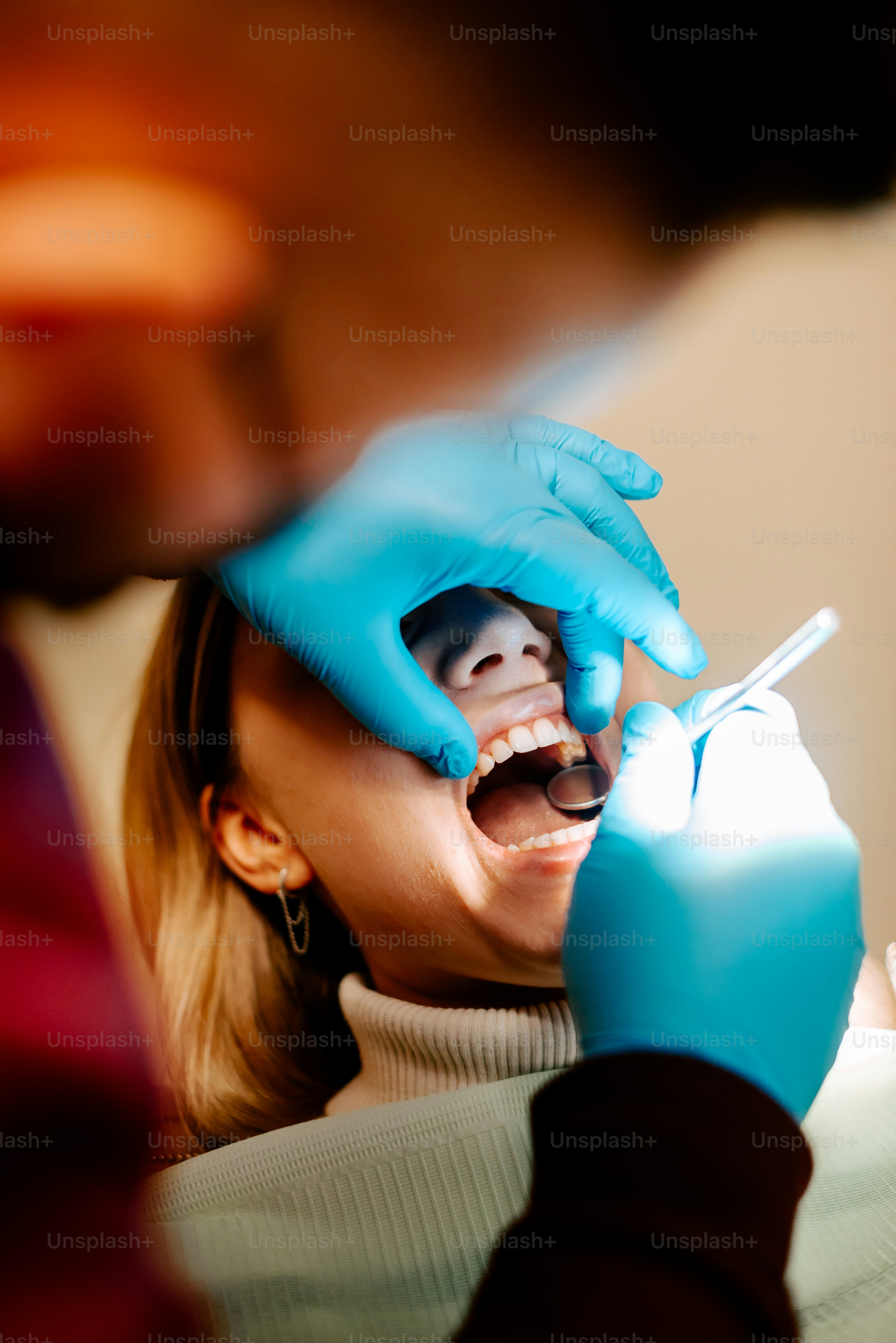 a woman getting her teeth checked by a dentist